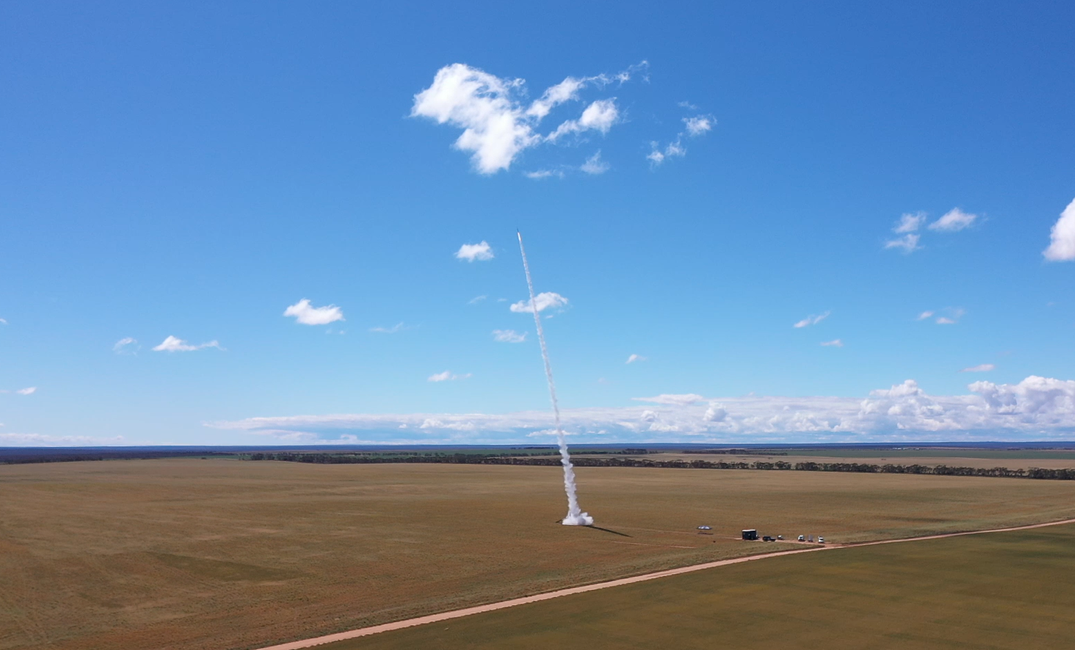 A rocket taking off from wide-open area in Australia during daytime